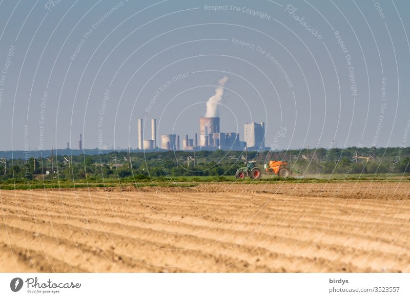 Braunkohlenkraftwerk Niederaußem, im Vordergrund ein Bauer welcher Pestizide auf sein Feld ausbringt. Braunkohlenverstromung und konventionelle Landwirtschaft ,verantwortlich für Klimawandel und Verseuchung der Umwelte