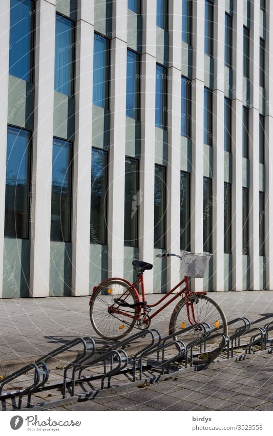 geparktes Fahrrad vor modernem Bürogebäude Damenrad Fahrradständer Gehweg Fassade Menschenleer Außenaufnahme Fenster Farbfoto Gebäude CO2-neutral