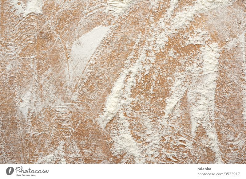 weißes Weizenmehl auf einen braunen Holztisch gestreut, Draufsicht Staubwischen Mehl Lebensmittel abstrakt Hintergrund Bäckerei Holzplatte Nahaufnahme Design
