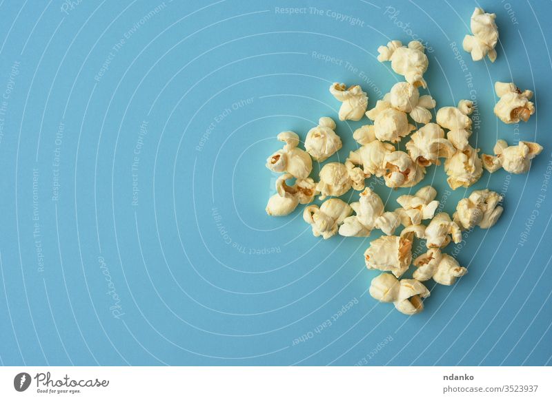 weißes köstliches Popcorn auf blauem Hintergrund, ein Platz für eine Inschrift Overhead Popkorn Salz gesalzen salzig Ernährung oben klassisch Nahaufnahme Farbe