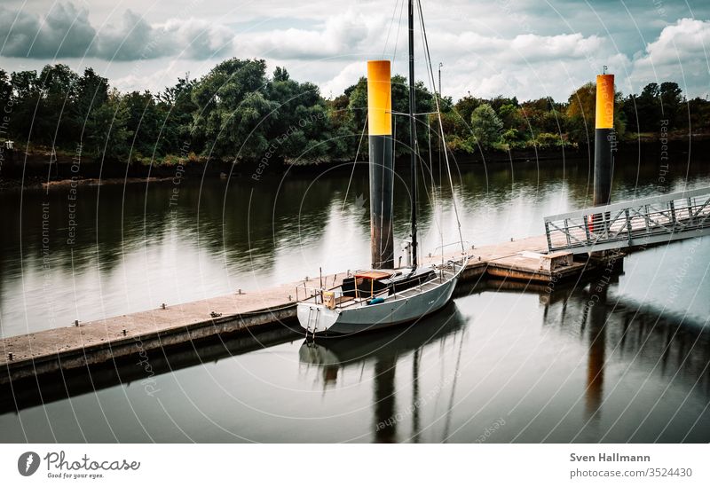 einsames Boot im Hafen Segelboot Segeln Jacht Himmel Wasser Urlaub Freiheit Segelschiff Abenteuer Außenaufnahme Ferien & Urlaub & Reisen Sommer Farbfoto