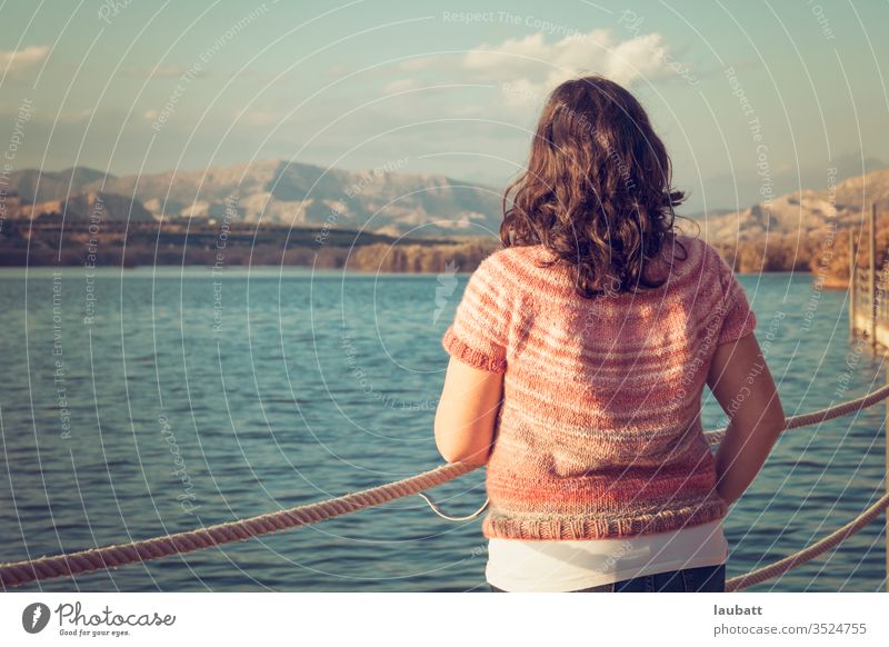 Frau, die auf das Seeufer starrt, Rückenporträt einer Frau, die am Dock zum Horizont blickt Tag Außenaufnahme Natur Landschaft Wasser Reflexion & Spiegelung