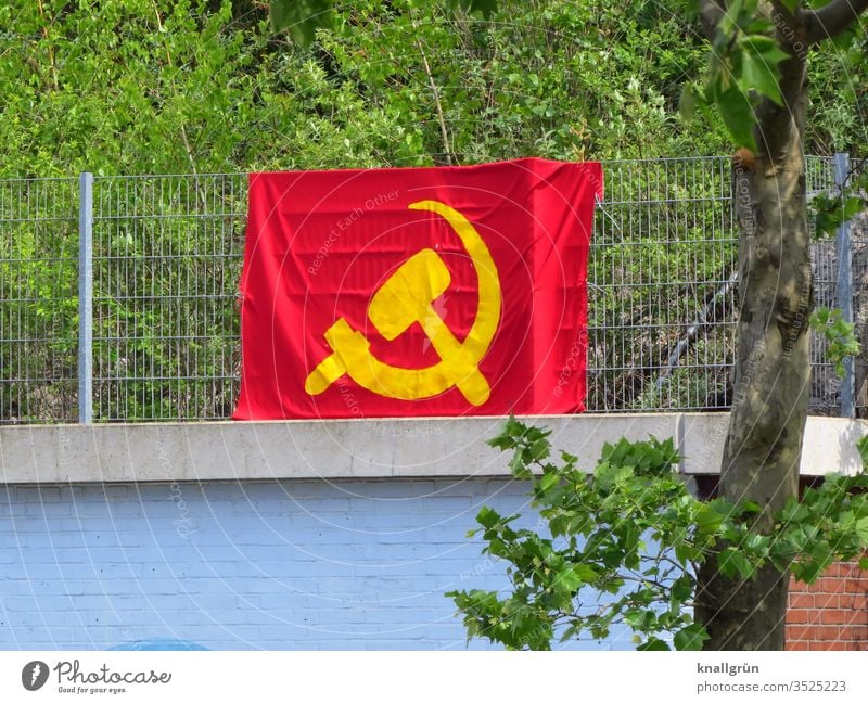 Große Hammer und Sichel Flagge an einem Metallzaun oberhalb einer Mauer befestigt Sowjetunion Fahne rot gelb Kommunismus Politik & Staat Symbole & Metaphern