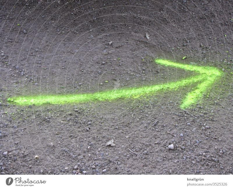 Neongelber leicht gebogener Pfeil auf den Boden gesprayt Schilder & Markierungen Richtung Graffiti neongelb sandiger Boden dreckig Zeichen Wegweiser Empfehlung