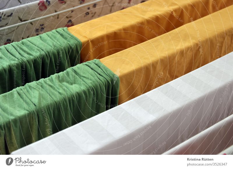 bettwäsche hängt zum trocknen auf dem wäscheständer bettlaken waschtag waschen sauber frisch trocken bunt farbig grün gelb weiß stoff textil gewebe baumwolle