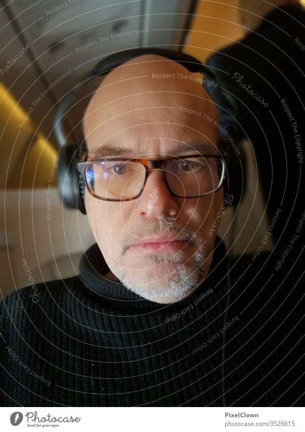 Ein Mann, der Musik hört Ein Mann allein Erwachsene Porträt 1 Mensch Brille Brillenträger Flugzeug