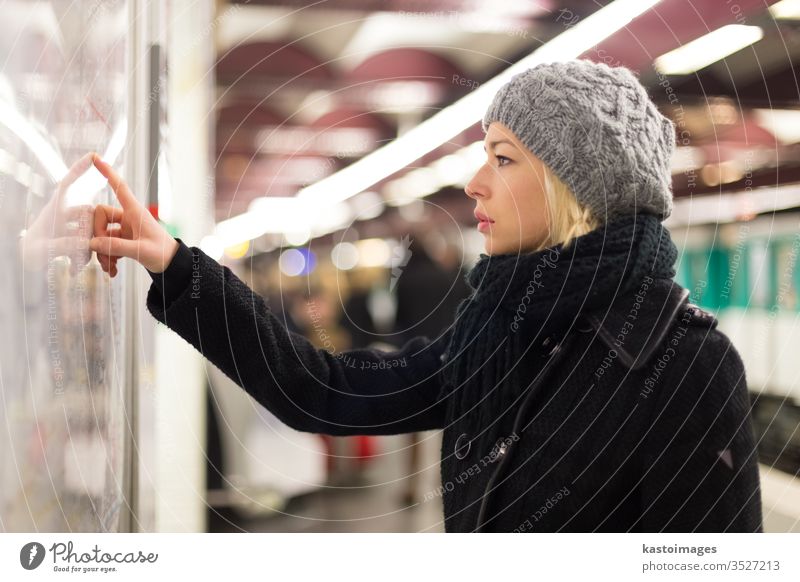 Dame schaut auf Kartentafel des öffentlichen Verkehrs. Landkarte U-Bahn Frau Station Arbeitsweg urban Panel Transport Zug Linie Großstadt Regie Öffentlich Suche