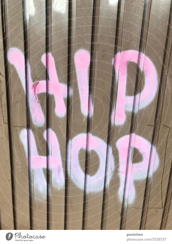 Graffiti auf Garagentor aus wellblech. Text „hip Hop“ garagentor Hip Hop wort text illegal jugendkultur Menschenleer Buchstaben Außenaufnahme Farbfoto
