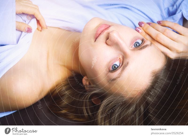 Nahaufnahme einer jungen schönen Frau in Blau, die im Bett liegt. Natürliche Schönheit. Selektiver Fokus. Filmstil romantisch Entspannungsbad Erholung Gesicht