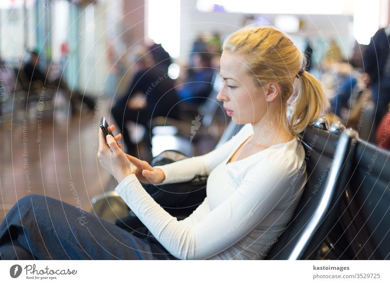 Weibliche Reisende, die während der Wartezeit ein Mobiltelefon benutzt. reisen Frau Reisender Station Passagier Telefon Gepäck Verkehr Flughafen Ausflugsziel