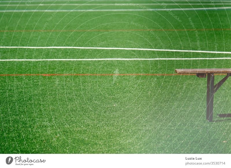 Leere Bank auf einem leeren Sportplatz, mit viel Sonnenschein Bierbank Rasen Rasenplatz Linien grün Fußball Spielen Fußballplatz Ballsport Außenaufnahme