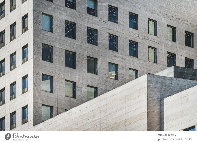 Geometrische Ansicht eines modernen Geschäftsgebäudes aus römischem Travertinmarmor Fassade Gebäude geometrisch Fenster Reihen Glas Perspektive Farbe im Freien