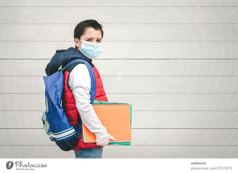 covid-19,Porträt eines Kindes mit medizinischer Maske und Rucksack auf dem Schulweg Coronavirus Virus Seuche Schule Schüler Pandemie Quarantäne