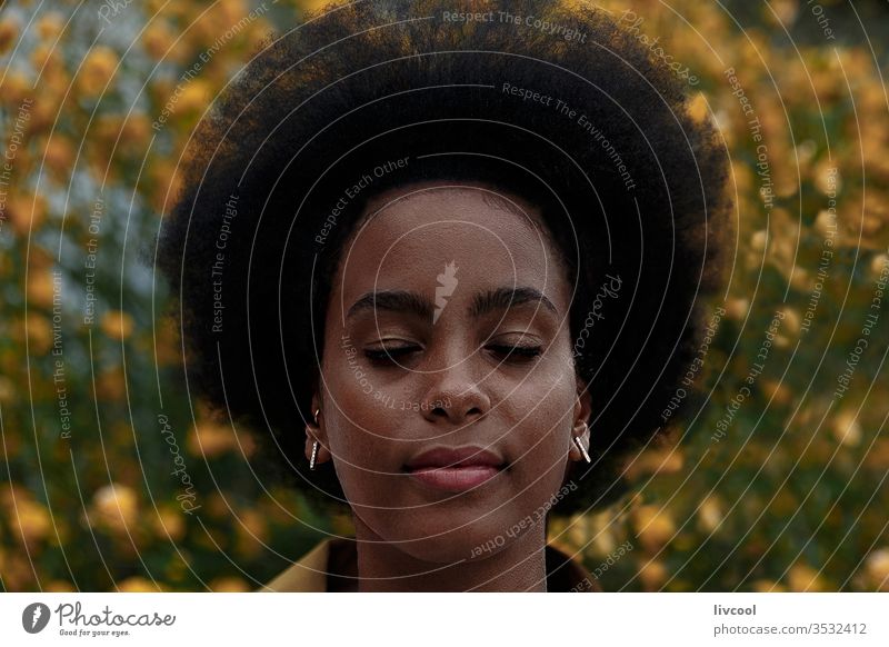 nachdenkliche Afro-Frau mit geschlossenen Augen in einem Garten schwarze Frau Mädchen Träumer Afrofrau geschlossene Augen jung Menschen Porträt Lifestyle cool