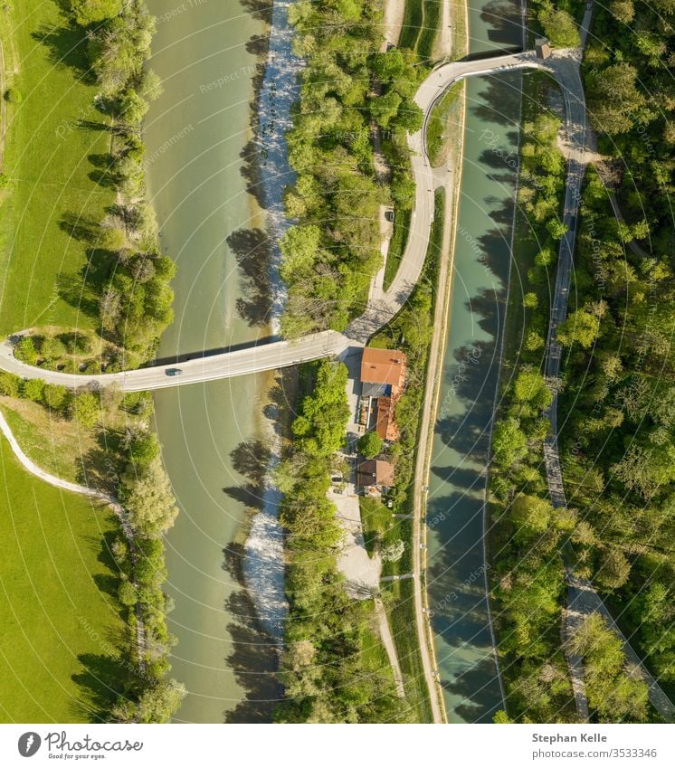 Draufsicht von einer Drohne auf ein fahrendes Auto an einer Brücke über einen Fluss mit einem Neffenwald und einem Haus Luftaufnahme Dröhnen PKW Natur Frühling