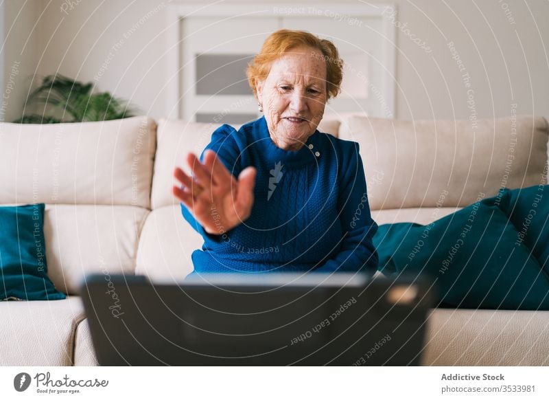 Ältere Frau kommuniziert mit einem Freund während eines Video-Chats am Laptop Videoanruf heimwärts Senior Sitzung benutzend online Gruß Lächeln abgelegen