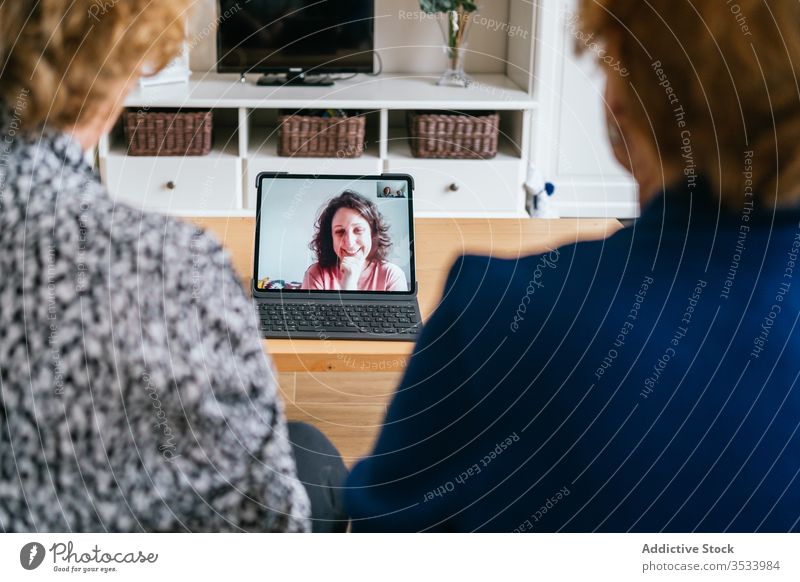 Frauen, die zu Hause Videogespräche am Laptop führen Videoanruf heimwärts Senior Sitzung benutzend online Freund heiter sich[Akk] sammeln gealtert Kommunizieren