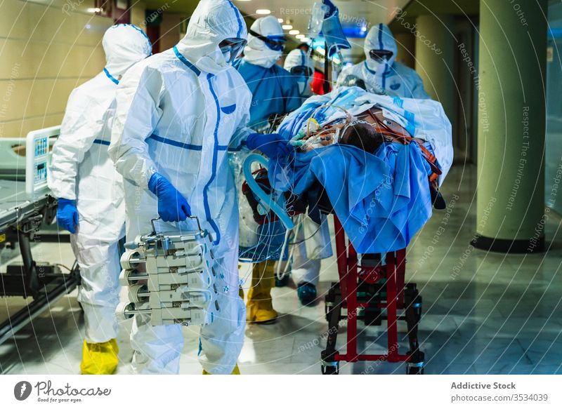 Eine Gruppe von Ärzten transportiert den Patienten in den Operationssaal Menschengruppe Arzt Krankenhaus geduldig viral Infektion Saal Klinik Uniform Mundschutz