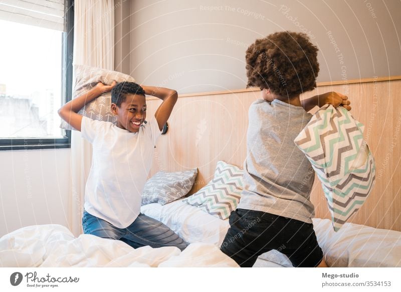 Zwei Brüder spielen zu Hause mit Kissen. Kinder Zusammensein Bruder Glück Schlafzimmer aufgeregt Porträt positiv aktiv Kissenschlacht bezaubernd Lifestyle