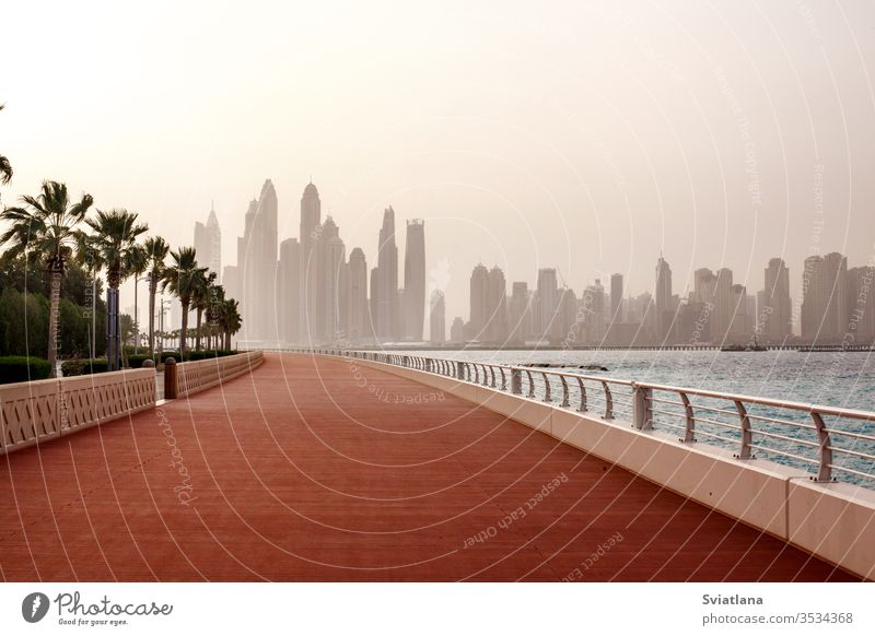 Atemberaubende Aussicht auf die Wolkenkratzer in Dubai im Morgengrauen. VEREINIGTE ARABISCHE EMIRATE Wellenbrecher Steine MEER Strand Blauer Himmel Landschaft