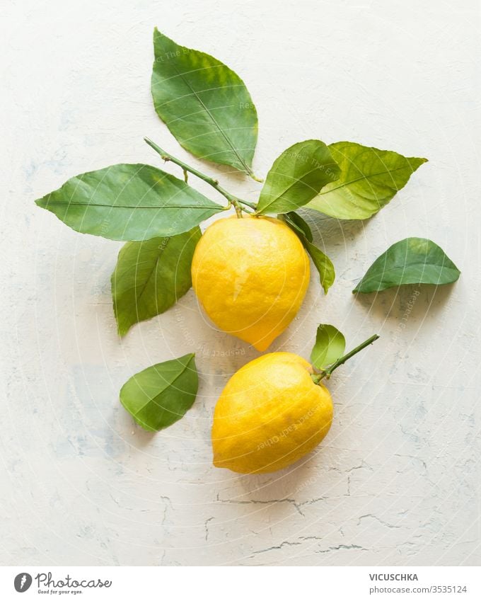 Reife Zitronen mit grüner Blattkomposition auf weißem Schreibtischhintergrund , Draufsicht. Organische Zitrusfrüchte. Flach gelegt. Konzept für gesunde Ernährung.