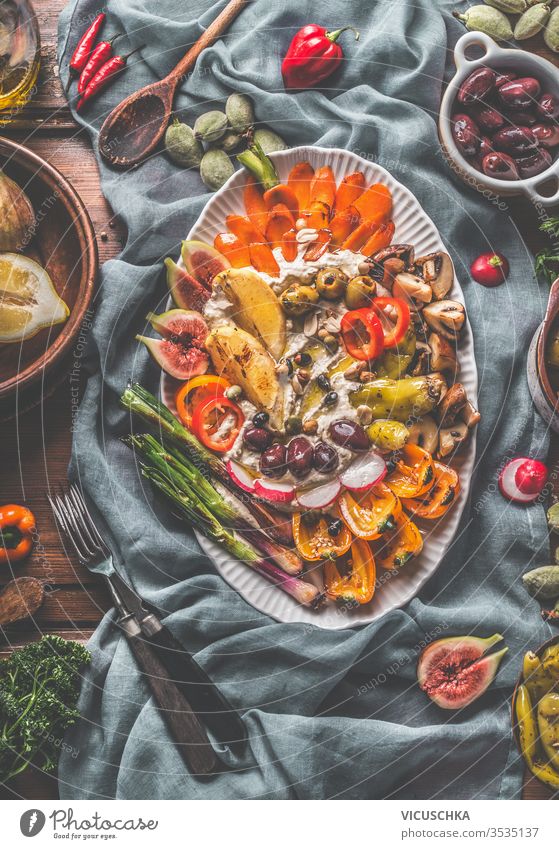 Veganer Hummus-Partyteller mit gebratenem, gegrilltem, frischem und eingelegtem Gemüse . Ansicht von oben. Gesunde Ernährung. Zwischenmahlzeit. Mediterrane Küche.