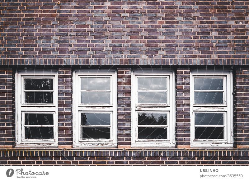 alte abgeblätterte Sprossenfenster in einer Klinkerfasade geometrisch symetrisch Geometrie Architektur Symetrie Fasade Holzfenster abgeblätterte Farbe Fenster