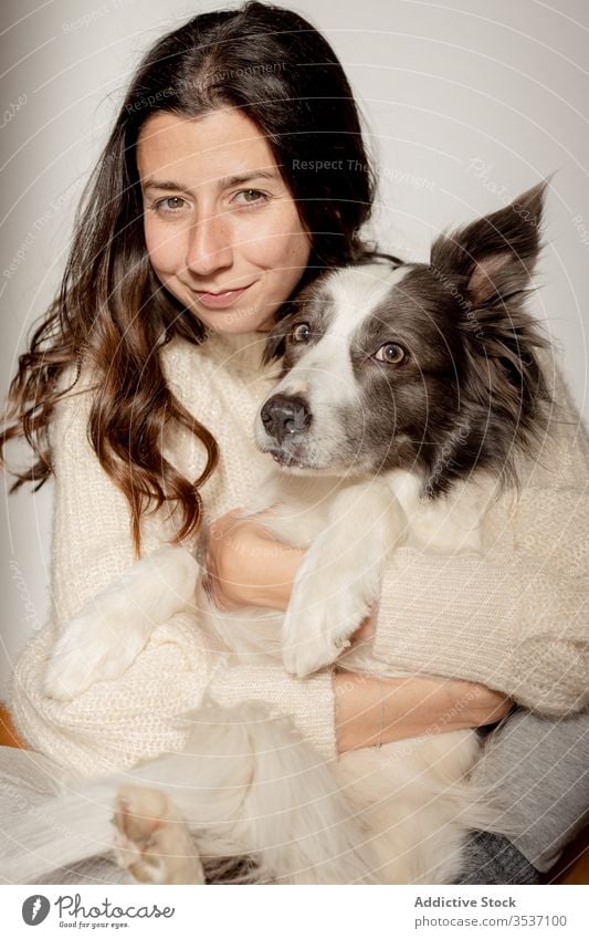 Glückliche Frau umarmt süßen, reinrassigen, grau-weißen Hund während der Bodenruhe Umarmen Stock Umarmung Pflege sitzen ruhen niedlich Freundschaft Haustier