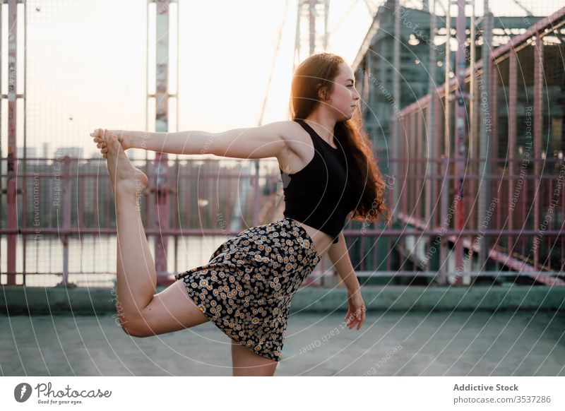 Ruhige Frau beim Yoga auf der Brücke üben Stadtbild beweglich Asana Herr des Tanzes Pose ruhig Großstadt urban Landschaft lässig Outfit Rock Übung Natarajasana