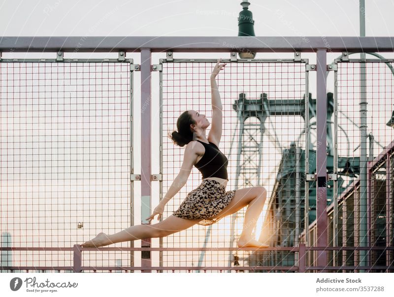 Anmutige Frau praktiziert Yoga auf der Brücke üben Gelassenheit industriell urban sinnlich Gleichgewicht halbmondförmiger Ausfallschritt Pose Zen schlank ruhig