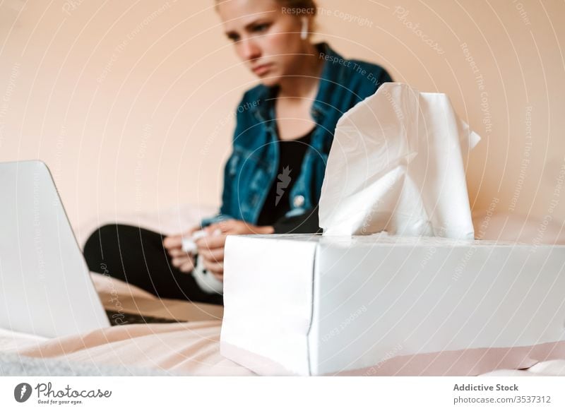 Frau schaut einen Film bei einem heißen Getränk und mit einem Laptop weinen Gesichtspapier Tränen traurig trinken verärgert heimwärts Tasse benutzend Bett