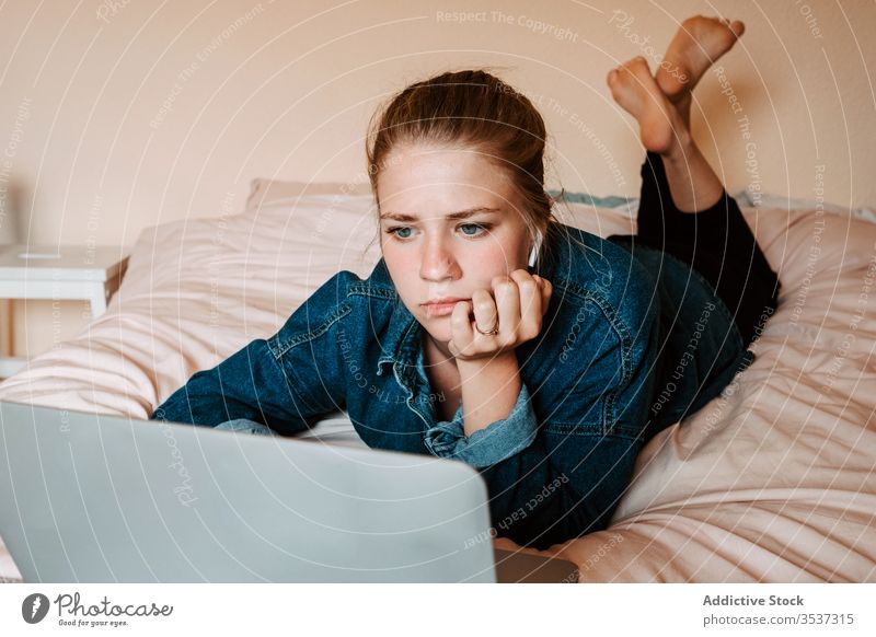 Frau schaut Film auf Laptop im gemütlichen Schlafzimmer heimwärts benutzend Bett liegend zuschauen Surfen soziale Netzwerke zuhören Interesse Filmmaterial