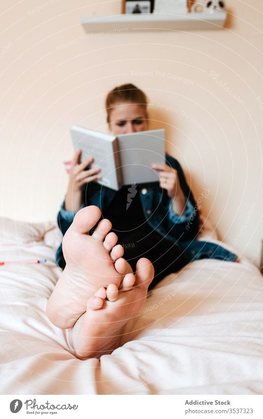 Nachdenkliche junge Frau liest Buch im hellen Schlafzimmer lesen heimwärts Bett Barfuß Leseratte allein sich[Akk] entspannen Fuß Lehrbuch Schüler ruhen Kälte