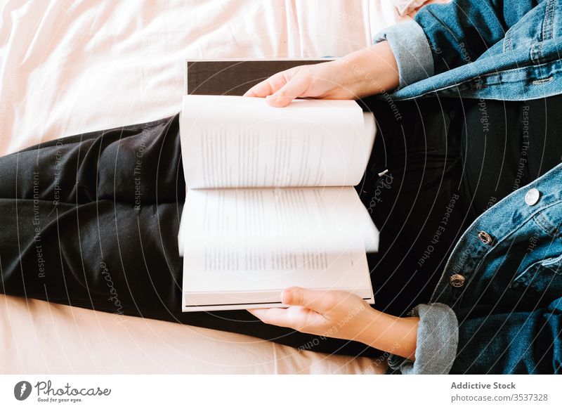 Gelangweilte Studentin blättert Lehrbuch in hellem, modernem Schlafzimmer Frau umdrehen Buch heimwärts Bett Schüler Kälte Leseratte gelangweilt