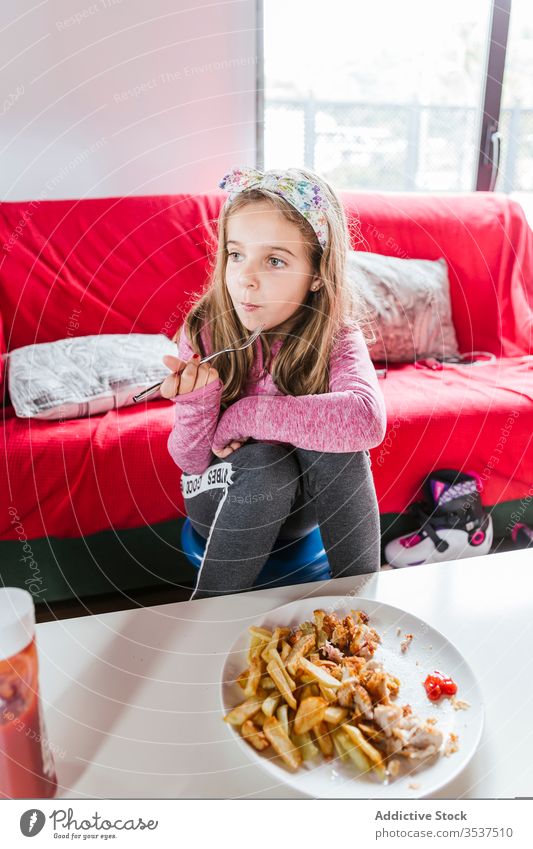 Mädchen isst zu Hause zu Mittag heimwärts essen Mahlzeit Abendessen Wohnzimmer Mittagessen Lebensmittel Sofa sitzen ruhen lässig geschmackvoll Speise Kind