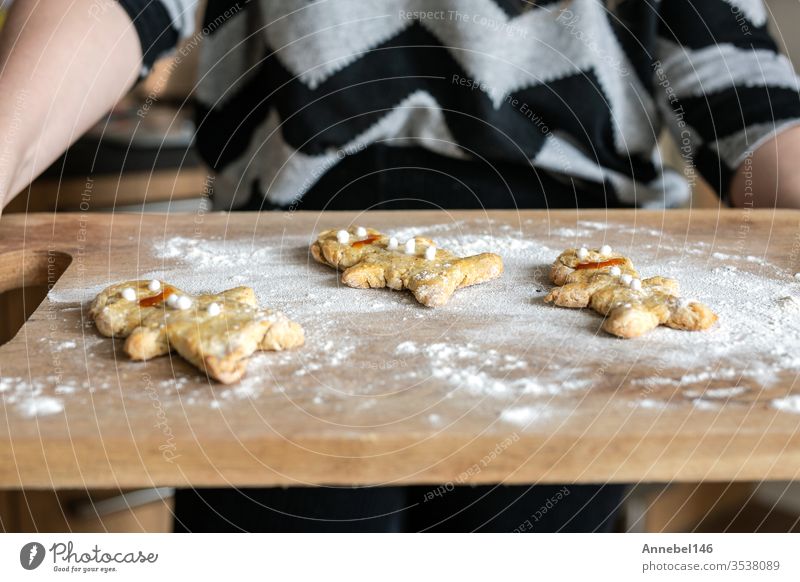 Frauenhände halten Backblech mit hausgemachten Lebkuchen Mann Kekse in der Küche selbstgemacht Feiertag Weihnachten Gebäck Lebensmittel festlich Hand