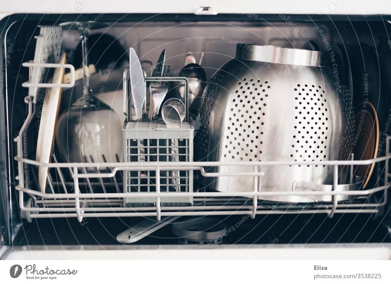 Sauberes Geschirr in einer kleinen Spülmaschine sauber Haushalt Geschirrspüler Geschirrspülen Besteck silber Haushaltsführung Küche Nudelsieb eingeräumt offen