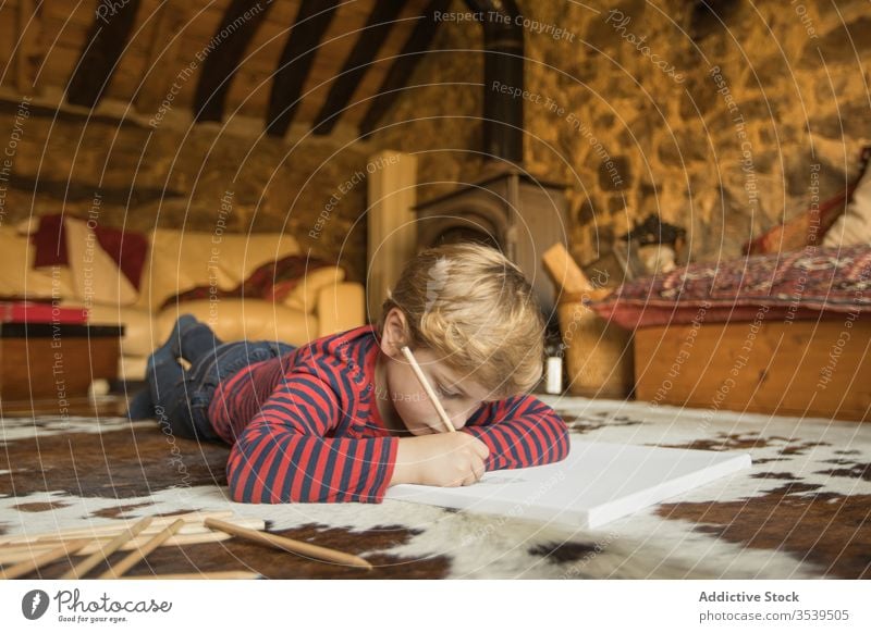 Kinderzeichnung mit Farbstiften im Skizzenbuch im Wohnzimmer Junge Haus Land Kabine Inspiration Natur jung Zeichnung Teppich Spanien Kantabrien Stein zeichnen