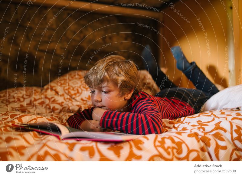 Gelassener Junge liest zu Hause im Bett ein Buch lesen Kind märchenhaft verträumt genießen Etage heimwärts Kantabrien Spanien Kindheit Freizeit Hobby