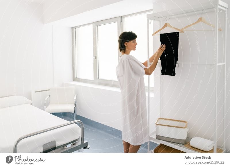 Frau entkleidet sich auf der Krankenhausstation Station sich[Akk] ausziehen hängen Hose Schiene Glück Erwachsener bereit Robe Verfahren medizinisch Klinik