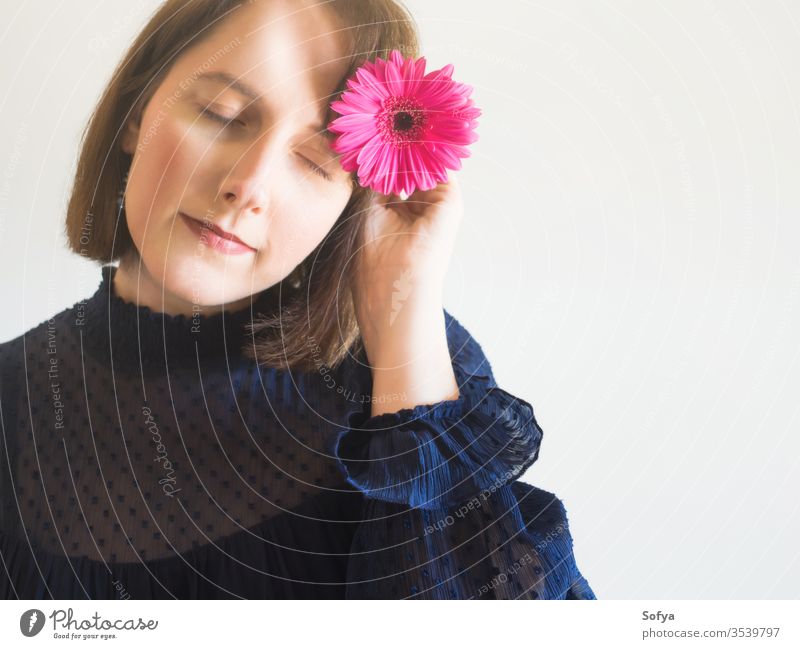 Wunderschönes weibliches Porträt mit rosa Gerbera-Blüte Frau Blume Schönheit Muttertag Mode eine einzigartig Haut Auge Pflege Gesicht jung Hand Beteiligung