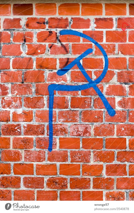 Hammer und Sichel - ein politisches Symbol mit blauer Farbe auf roten Backstein gesprüht Symbole & Metaphern Kommunismus Politik & Staat Macht Russland