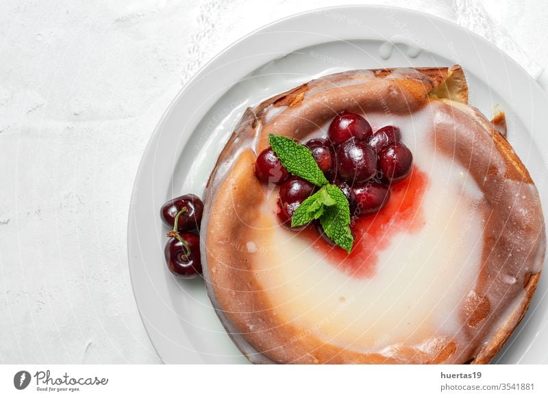Hausgemachter Käsekuchen mit Kirschen und Minze auf weißem Hintergrund selbstgemacht Kirsch-Käsekuchen süß Frucht Dessert Kuchen Lebensmittel rot Beeren