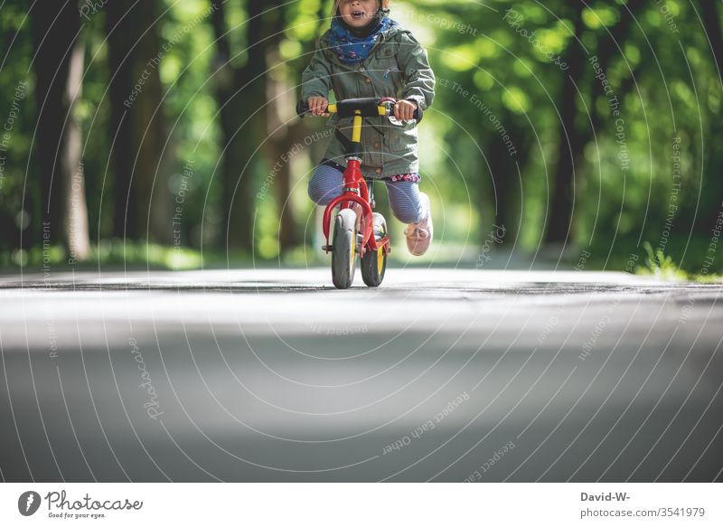 Kind fährt mit dem Fahrrad draußen durch die Natur ein