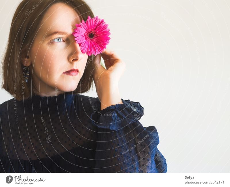 Wunderschönes weibliches Porträt mit rosa Gerbera-Blüte Frau Blume Schönheit Muttertag Mode eine einzigartig Haut Auge Pflege Gesicht jung Hand Beteiligung