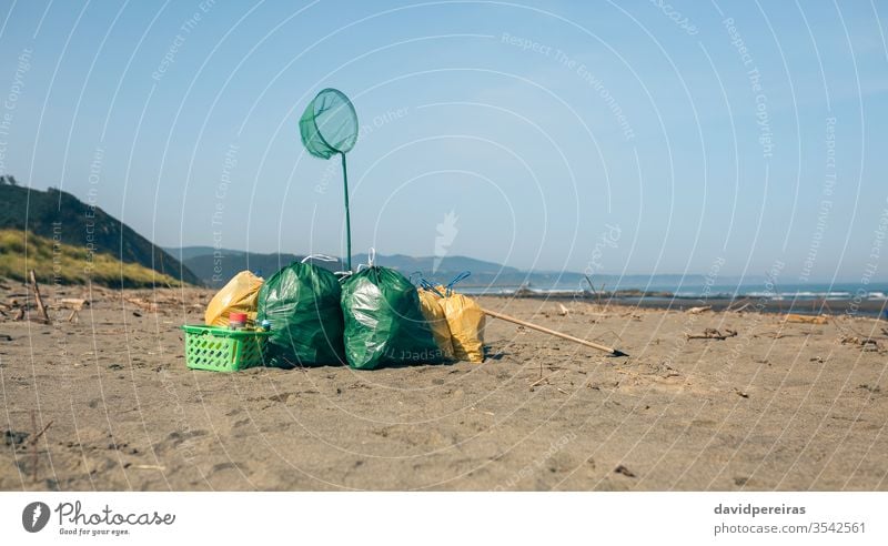 Müllsäcke und Utensilien am Strand danach Sauberkeit gesammelt Umweltbewusstsein Sand Natur Abfall Küste Problematik umgebungsbedingt Ufer verseucht Tag Konzept