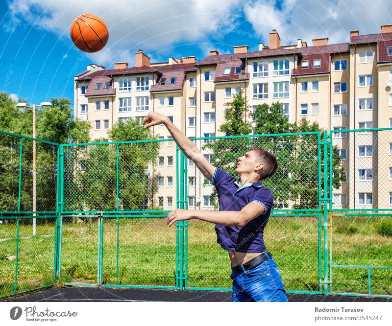 junger Mann trainiert an einem sonnigen Sommertag auf dem Spielplatz bei einem Basketballspiel Training Ball Sport aktiv Athlet Spieler passen Gericht Lifestyle