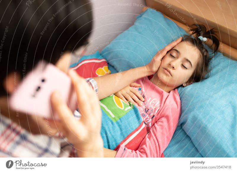 Mutter besorgt über die Temperatur ihrer Tochter und ruft den Arzt Thermometer Mädchen Fieber Kaukasier Menschen Pflege Krankheit Grippe kalt krank unwohl Anruf