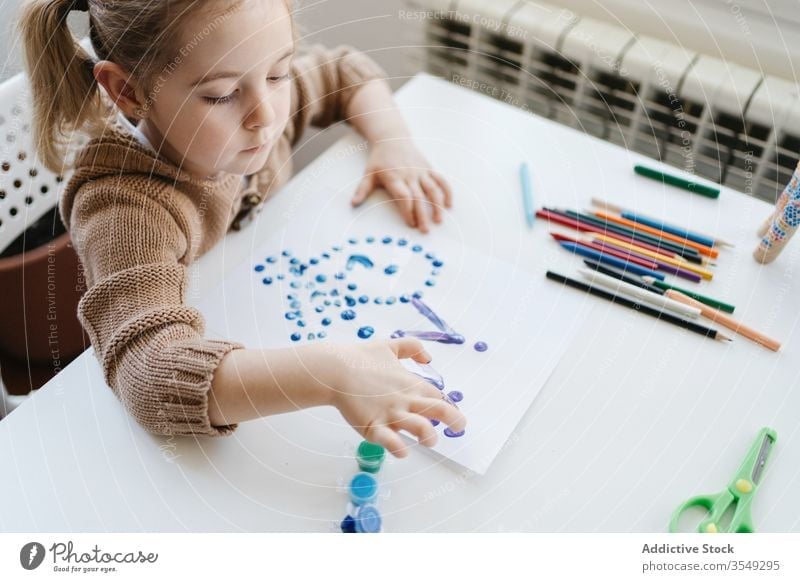 Von oben ein kleines Mädchen, das zu Hause Gouache zum Zeichnen mit den Fingern auf Papier benutzt Zeichnung heimwärts Kind Farbe Kindergarten Kunst kreativ