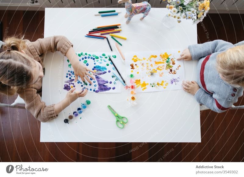 Bruder und Schwester im Vorschulalter malen gemeinsam zu Hause Kinder heimwärts zeichnen Farbe kreativ spielen Vorschule Atelier Wohnzimmer Gouache farbenfroh